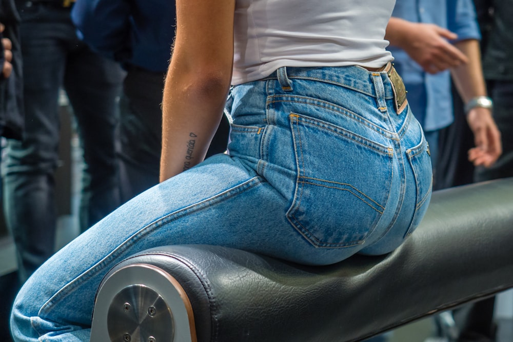 woman sitting on black leather surface close-up photographyt