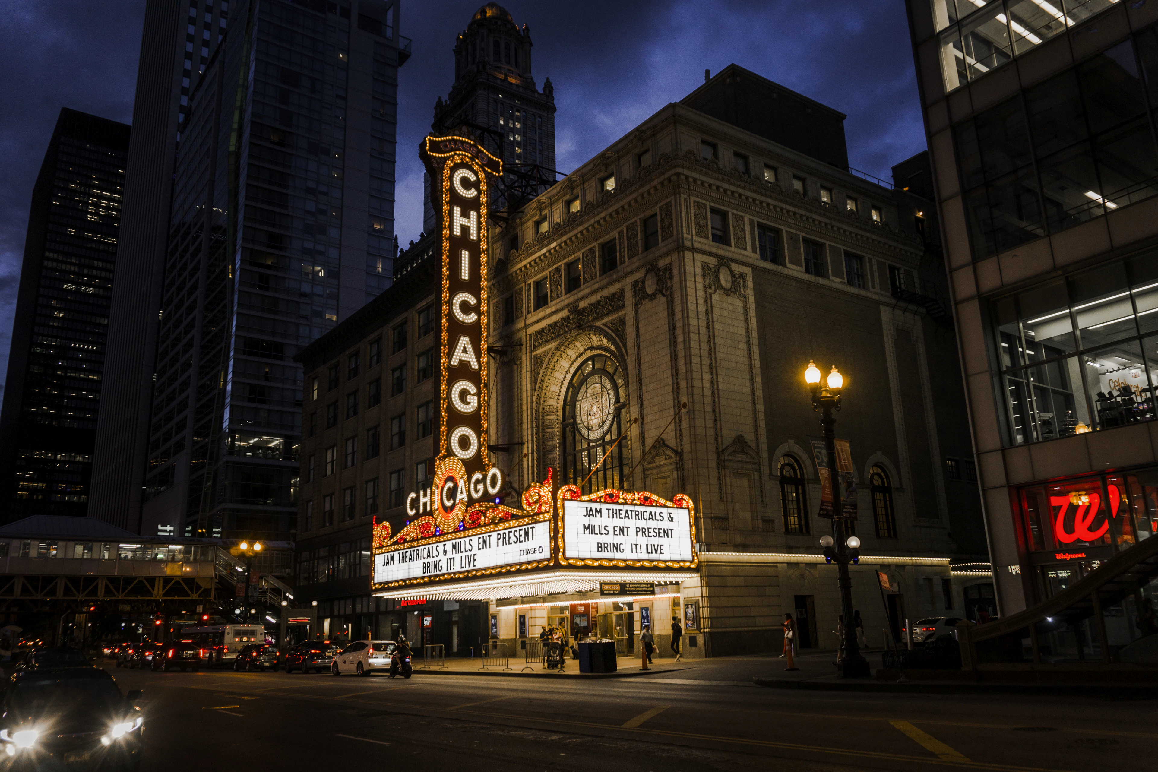 The Chicago Theatre's marquee glows red against the night sky above a quiet downtown street.