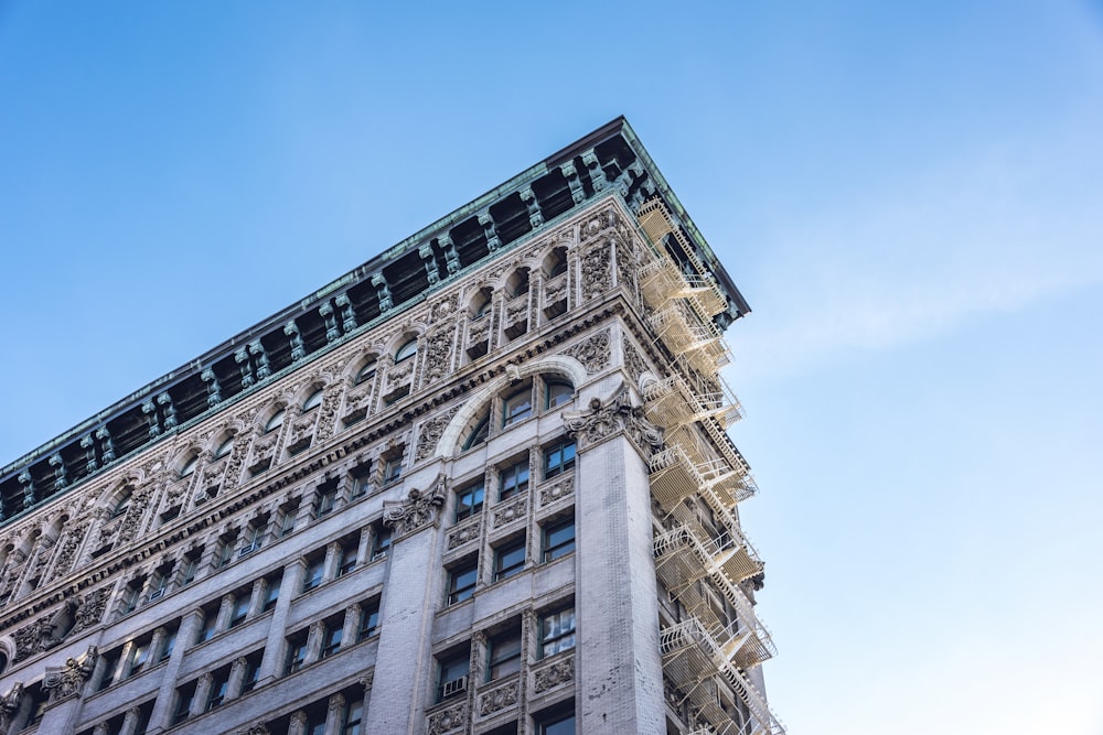 fotografía de ángulo bajo de un edificio de gran altura de hormigón de estilo europeo bajo un cielo azul tranquilo