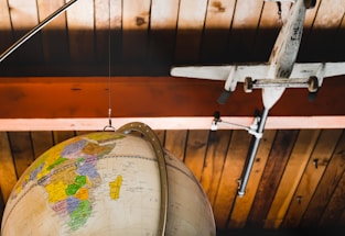 A modern travel-themed image featuring a globe and airplane.