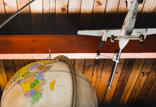 A modern travel-themed image featuring a globe and airplane.