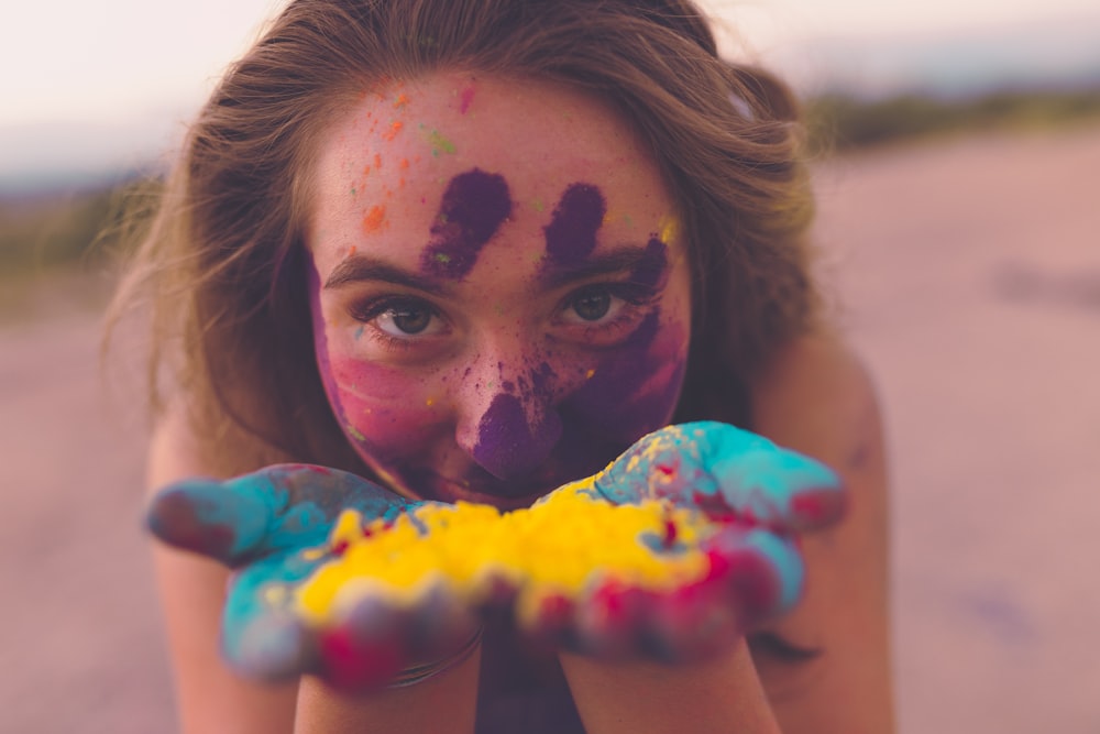 mulher com pós de coloração no rosto e na mão