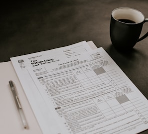 black ceramic mug beside white printer paper