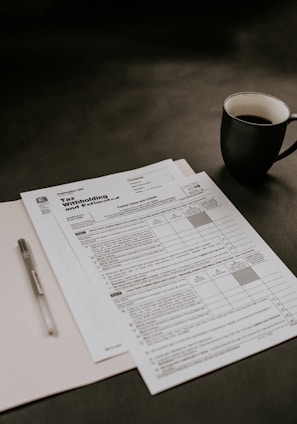 black ceramic mug beside white printer paper