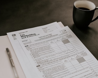 black ceramic mug beside white printer paper