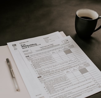 black ceramic mug beside white printer paper