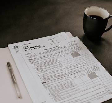 black ceramic mug beside white printer paper