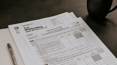 black ceramic mug beside white printer paper