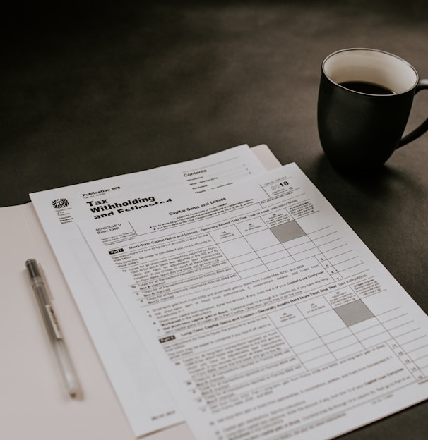 black ceramic mug beside white printer paper