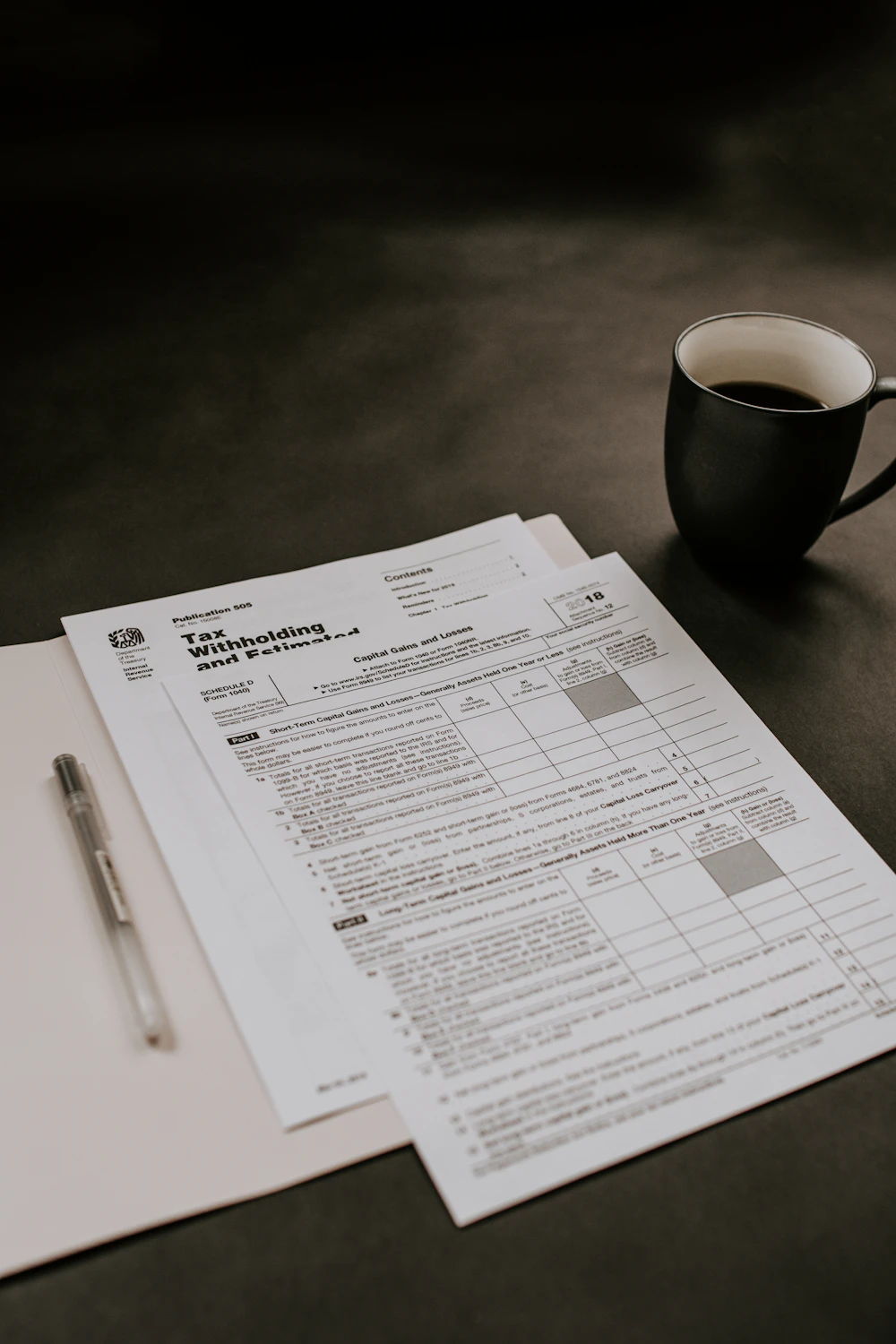 Tax forms beside a black coffee cup