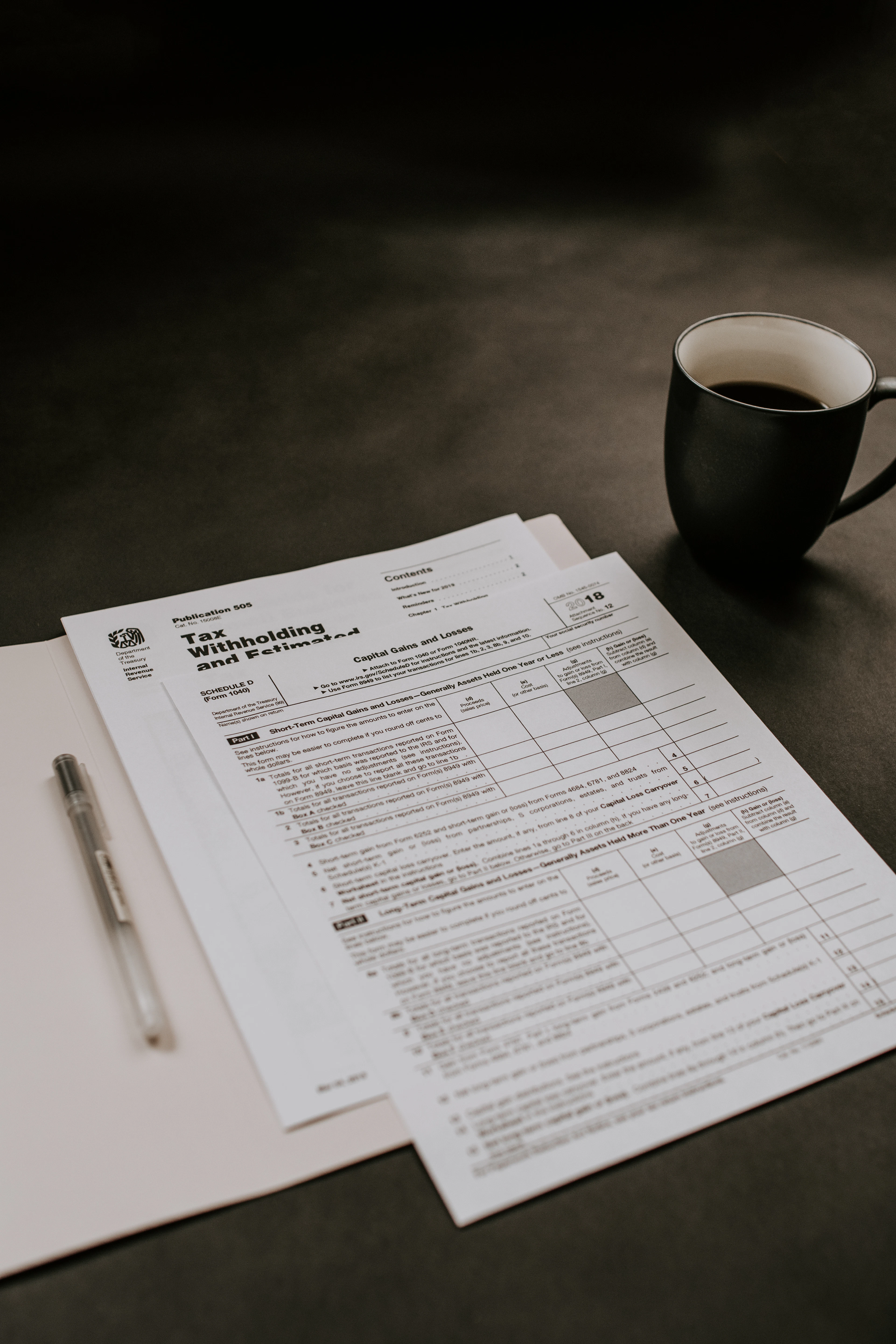 A small business owner filling out a GST registration form on a laptop beside invoices and a calculator.