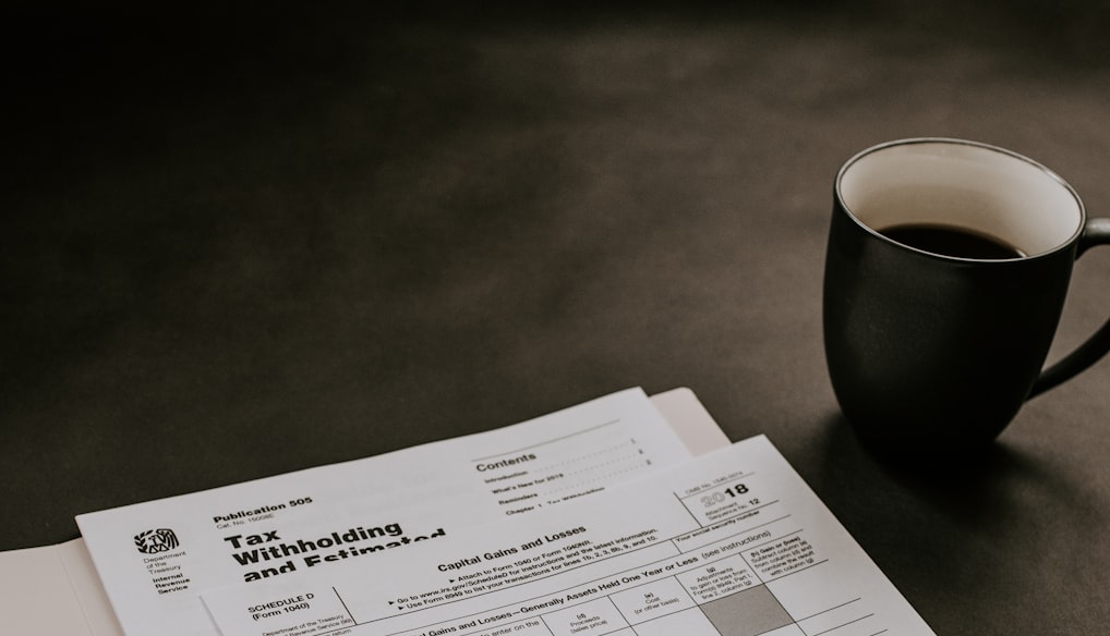 black ceramic mug beside white printer paper