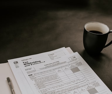 black ceramic mug beside white printer paper