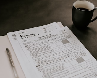 black ceramic mug beside white printer paper