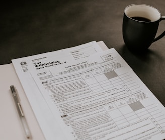 black ceramic mug beside white printer paper