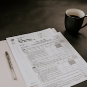 black ceramic mug beside white printer paper