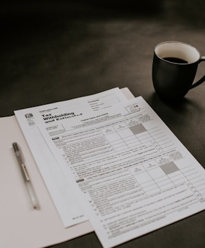 black ceramic mug beside white printer paper