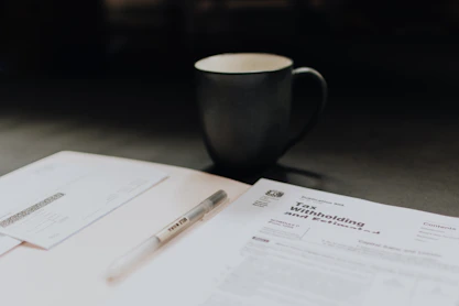 Close-up of hands analyzing tax forms and financial charts on a desk.