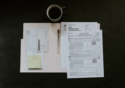Close-up of hands preparing income tax returns with organized paperwork.