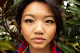 A minimalist portrait of a woman surrounded by greenery, reflecting calm and nature.