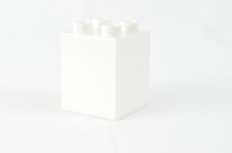 a white box with four white candles in it