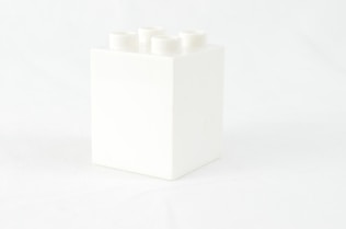 a white box with four white candles in it