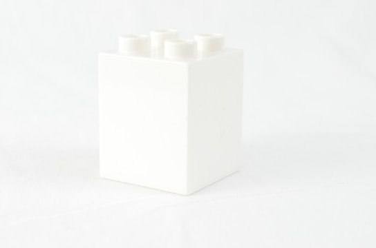 a white box with four white candles in it