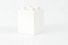 a white box with four white candles in it