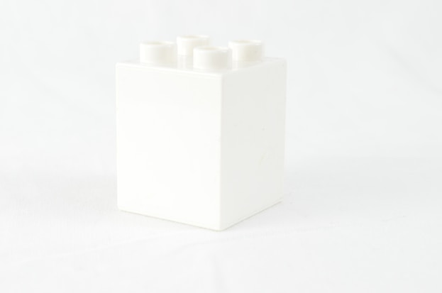 a white box with four white candles in it