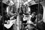 grayscale photo of people sitting on train chairs