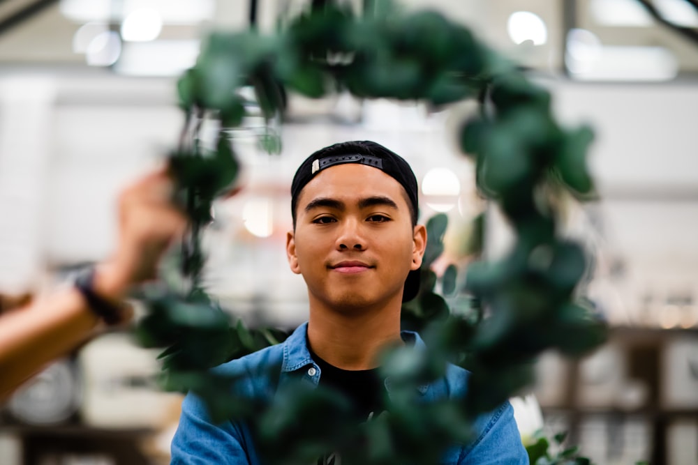 man in blue collared shirt through leaf wreath