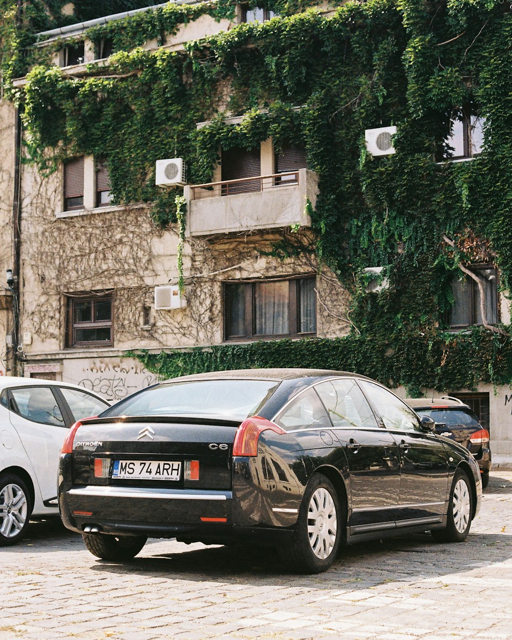 black car parked beside building