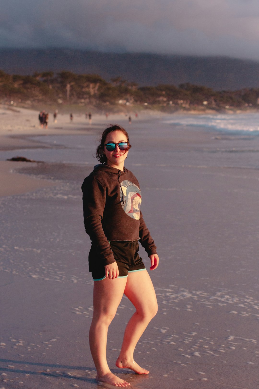 woman wearing black pullover hoodie standing on beach