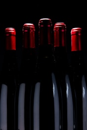 five upright black bottles