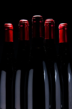five upright black bottles