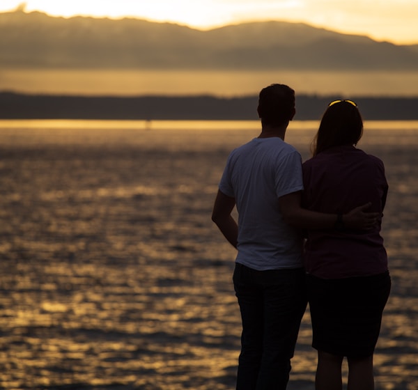 couple standing near beach during sunset