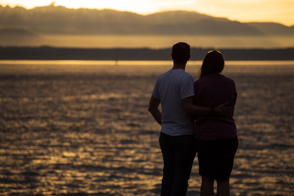 couple standing near beach during sunset