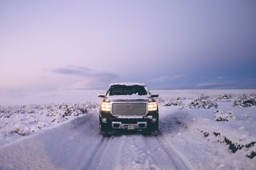 black GMC Sierra Denali on snow covered road