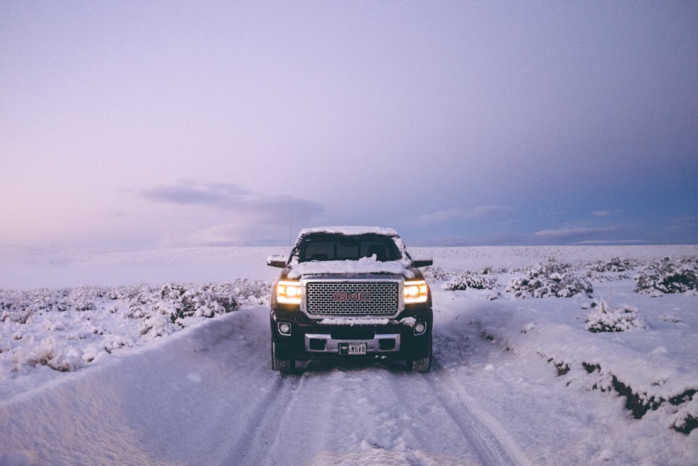 black GMC Sierra Denali on snow covered road