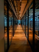 glass paneled long wooden floored hallway