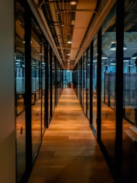 glass paneled long wooden floored hallway