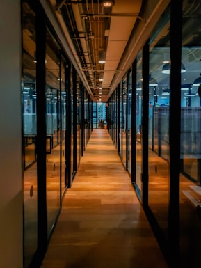 glass paneled long wooden floored hallway