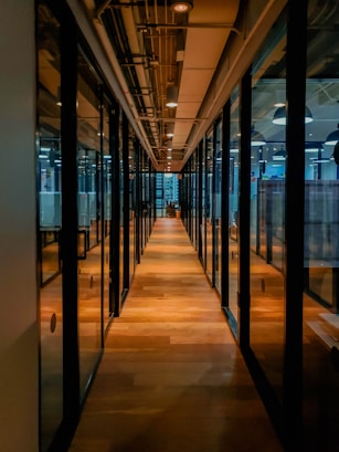 glass paneled long wooden floored hallway