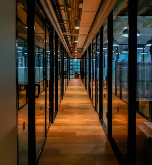 glass paneled long wooden floored hallway