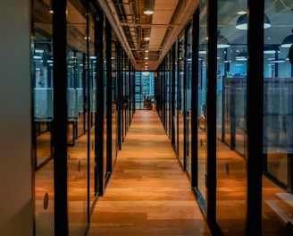 glass paneled long wooden floored hallway