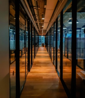 glass paneled long wooden floored hallway