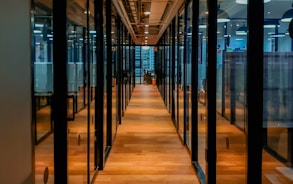 glass paneled long wooden floored hallway