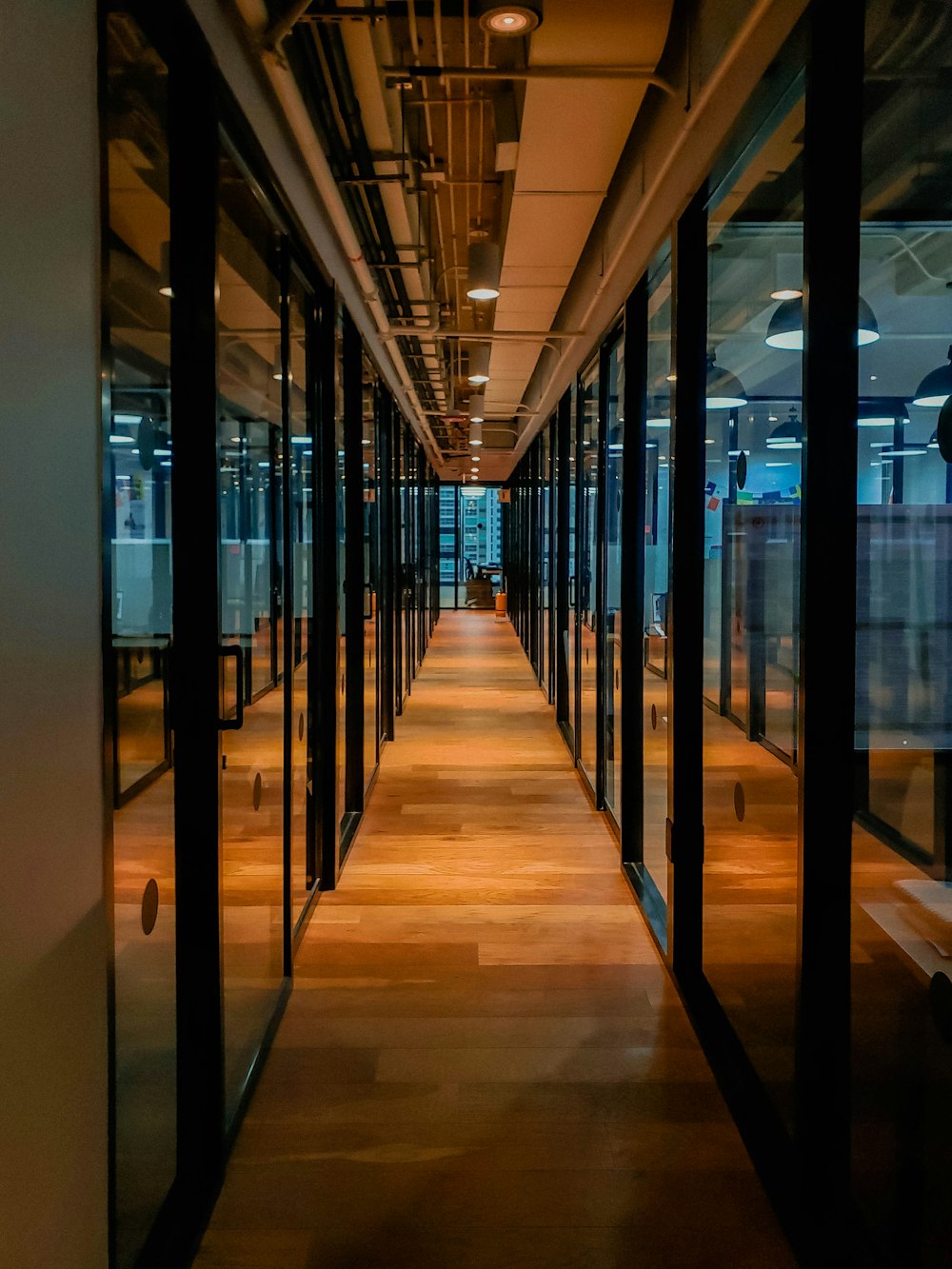 glass paneled long wooden floored hallway