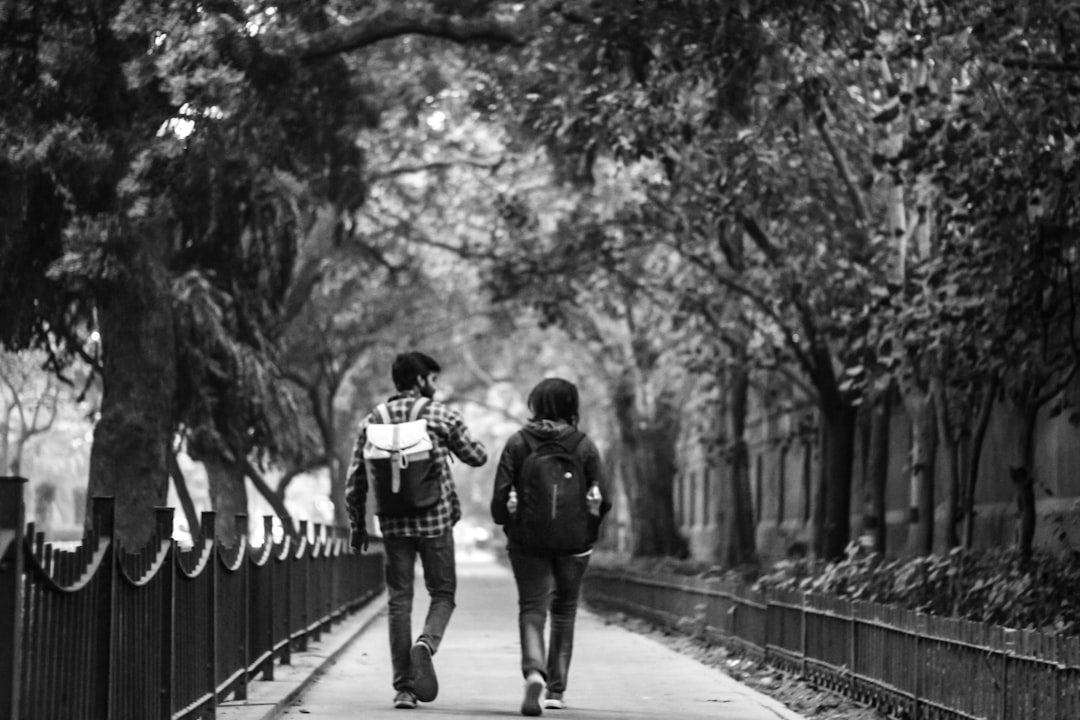 grayscale photography of couple on road,