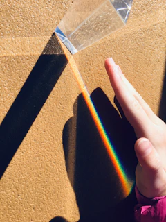 A close-up of a glass prism splitting sunlight into vibrant rainbow colors.